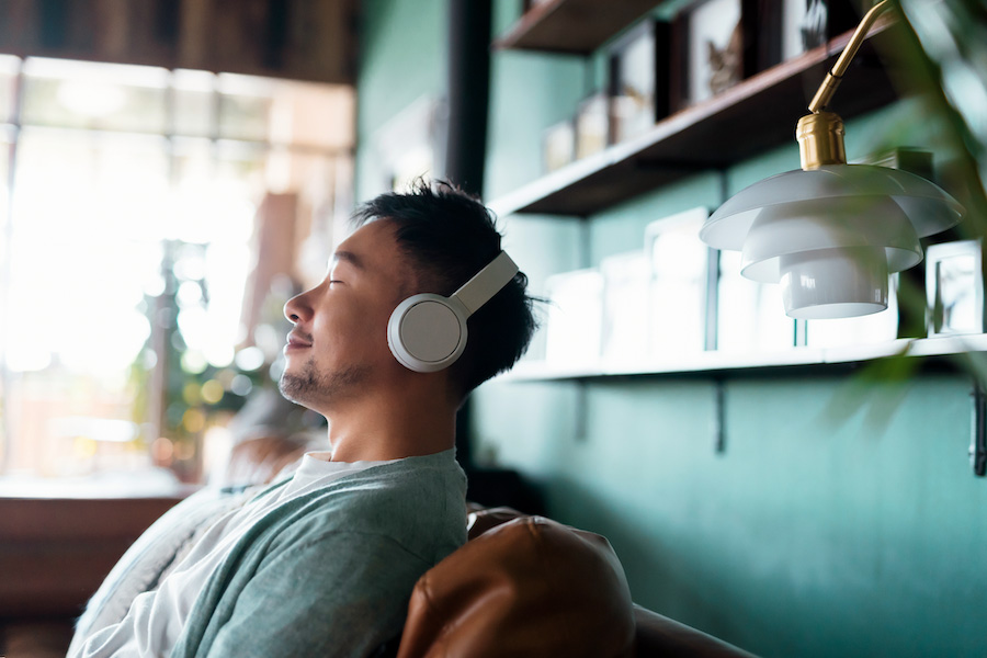 person wearing headphones and closing eyes